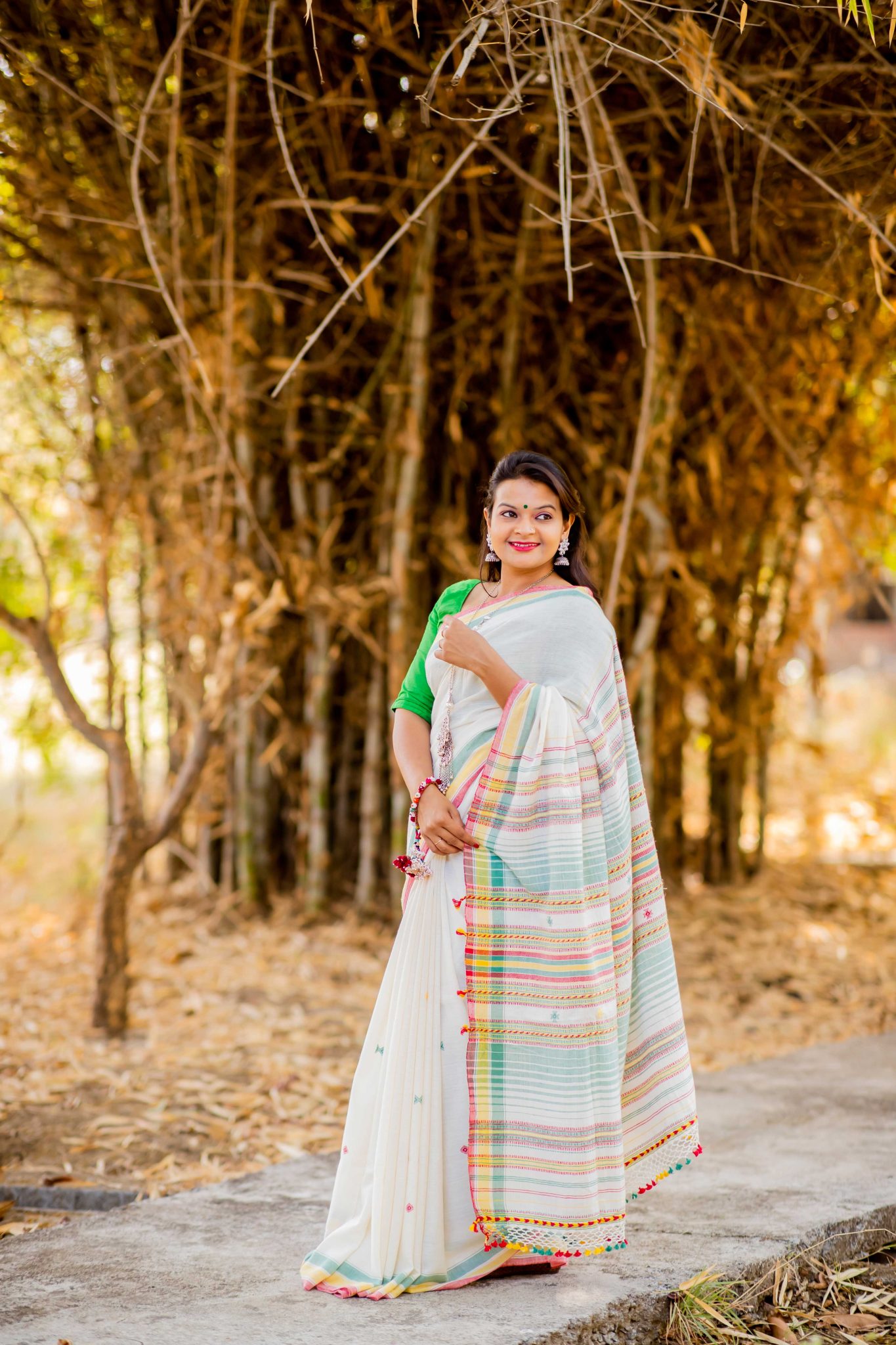 White coloured pure handloom kala cotton bhujodi weave saree with red, yellow and green coloured woven palla